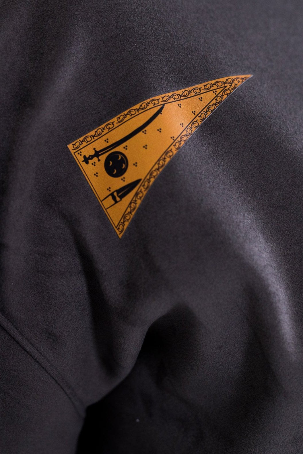Detail of the orange Nishan Sahib pennant embroidered on a Sojourn Arts garment