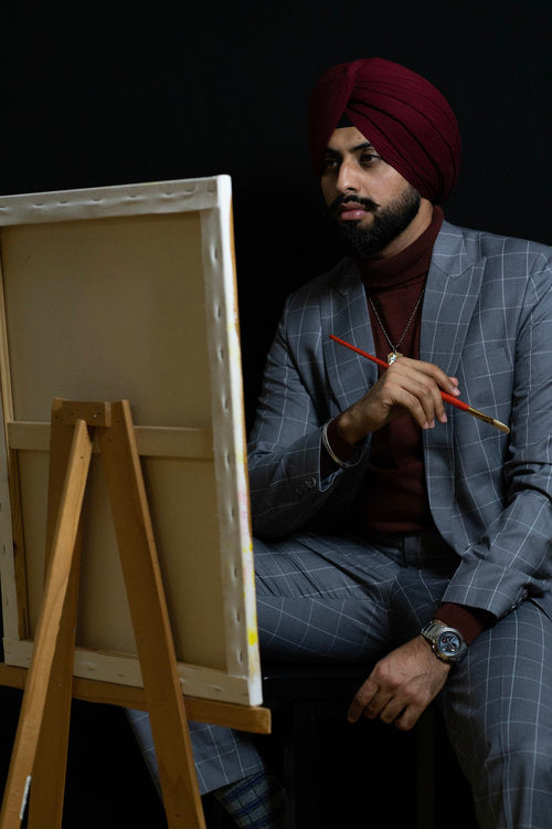 Armaan Bhattal, artist and founder of Sojourn Arts, beside his easel